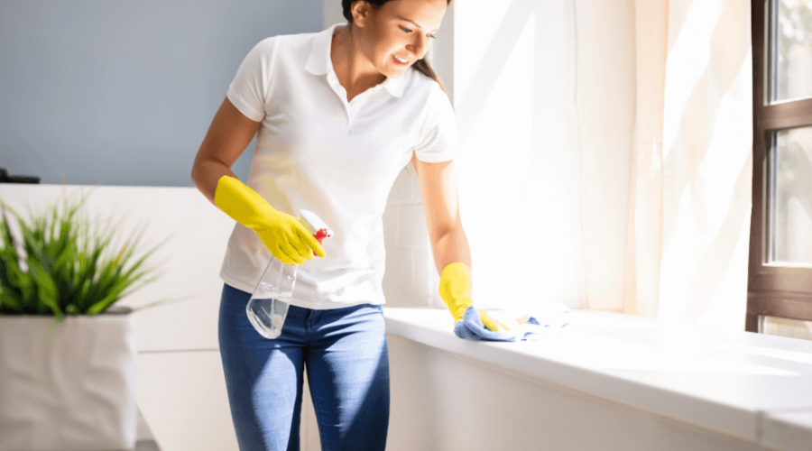 a woman in white t shirt is cleaning a countertop