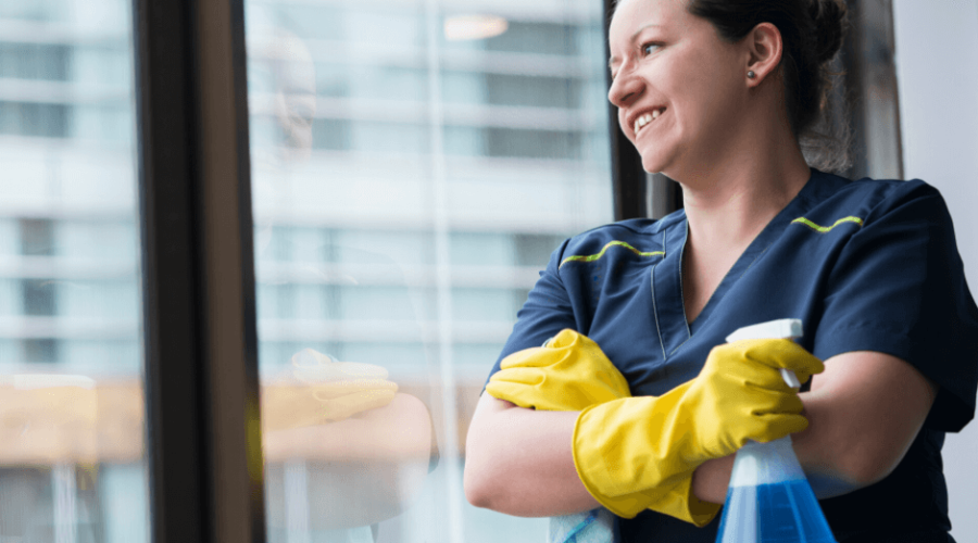 a woman with a spray bottle is looking out of a window